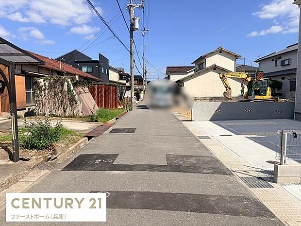前面道路は幅がしっかりと確保されており見通しの良いまっすぐな道が続いています。周囲には住宅が並び静かな環境が感じられます。道路は整備されていて歩きやすさにも配慮されています。