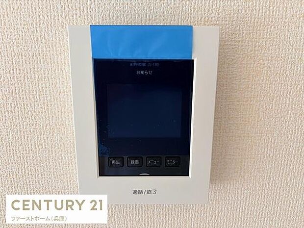 壁に設置されたカラーモニター付きのインターホンです。来訪者の確認ができ操作もシンプルで扱いやすいデザインです。スタイリッシュな白枠が室内の雰囲気にも調和します。防犯意識の高い方にも適しています。