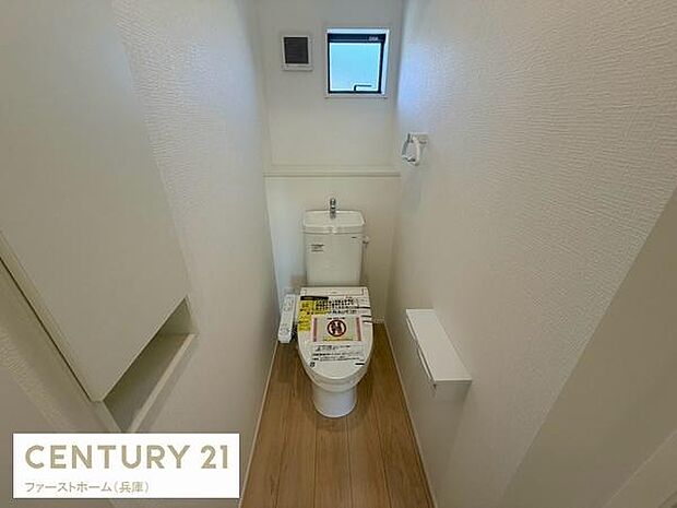 明るさを感じる窓付きのトイレです。ナチュラルな床材で空間がすっきりとしています。壁紙や設備はシンプルなデザインです。ペーパーホルダーや収納など必要な機能も備えています。