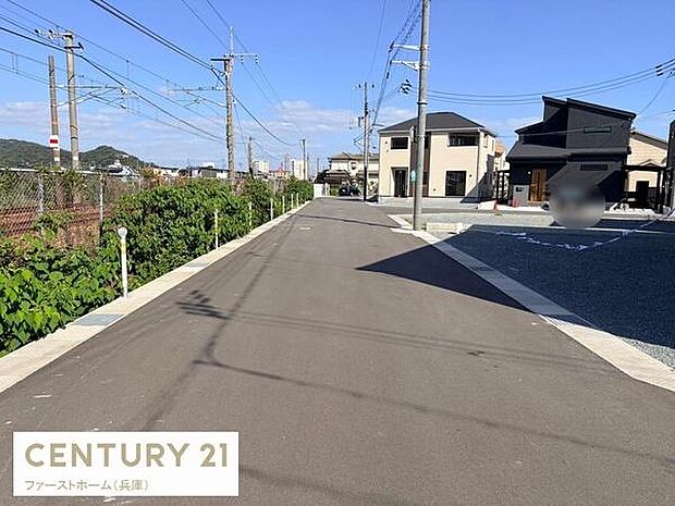 前面道路は幅員があり車の通行も安心して行えます。両側には整然とした住宅が並び電柱や配線もきれいに整理されています。道沿いには緑も感じられるエリアです。