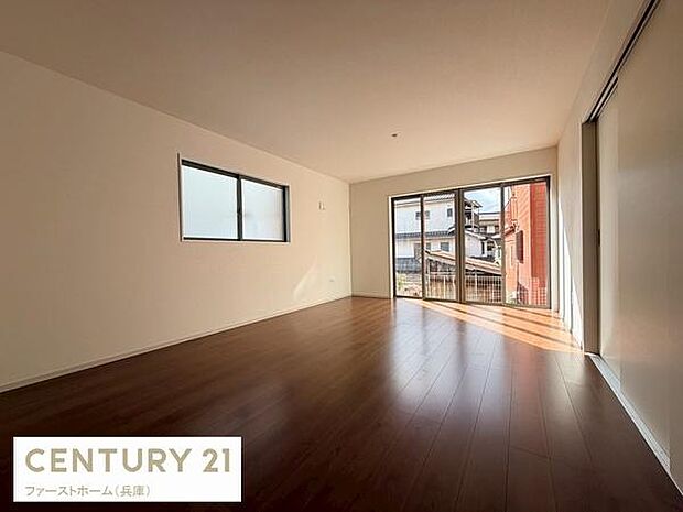 大きな窓から明るい自然光が差し込むリビングです。シンプルな内装で家具のレイアウトも自由自在。ゆとりのある広さが魅力的な空間です。床材の落ち着いた色合いが全体を引き締めます。