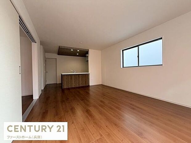 広々とした空間が広がるリビングです。床材には木目調が使用されており落ち着いた雰囲気が特徴です。大きな窓からは明るい光が差し込みます。壁や天井もシンプルなデザインとなっています。