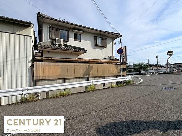 建物は落ち着いた雰囲気の外観で角地に位置しています。周囲の道路も広めで車の出入りに便利です。住宅の前にはガードレールが設置されているため安全面も考慮されています。