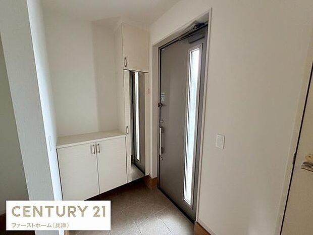 玄関には収納スペースが充実しておりすっきりとした印象です。明るい採光窓付きの扉が空間を広く感じさせます。全体的にシンプルで使いやすい玄関です。収納棚の配置が使い勝手を高めています。