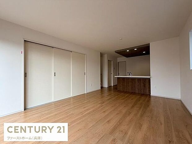 ナチュラルな色合いのフローリングが空間を広く見せます。大きな窓から自然光が入ります。シンプルな内装で家具の配置がしやすいです。キッチンとリビングが一体になった設計です。収納スペースも確保されています。