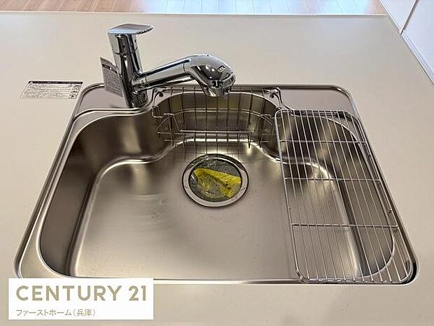 シンプルで清潔感のあるシンクが特徴的です。水栓の位置が使いやすく設計されています。作業スペースが確保されていて使い勝手に配慮されています。水切りラックが備え付けられています。