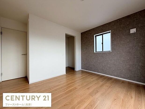 落ち着いた色合いの壁が特徴的な寝室です。窓から光が差し込み開放感のある空間になっています。床は木目調で手入れもしやすくシンプルな内装が魅力です。収納スペースも確保されています。