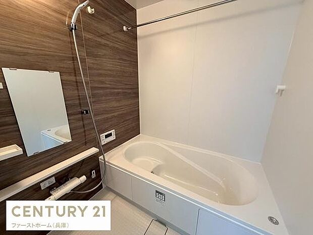 木目調のアクセントパネルが落ち着いた雰囲気を演出しています。浴槽はゆったりとしたデザインで快適にご使用いただけます。洗い場スペースも十分に確保されておりお手入れしやすい仕様です。