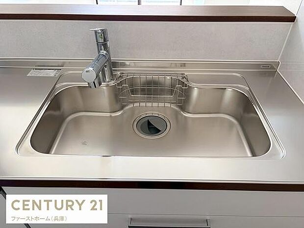 ステンレス素材が特徴的なキッチンシンクです。水栓はシンプルなデザインで使いやすい印象です。シンク周りは手入れがしやすそうな仕上げになっています。奥行きも十分に確保されています。