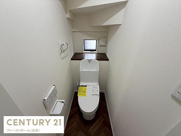 コンパクトな空間にトイレ設備が効率的に配置されています。小窓から外光が入るため明るさも感じられます。棚が備え付けられているのでちょっとした収納としても活用できます。