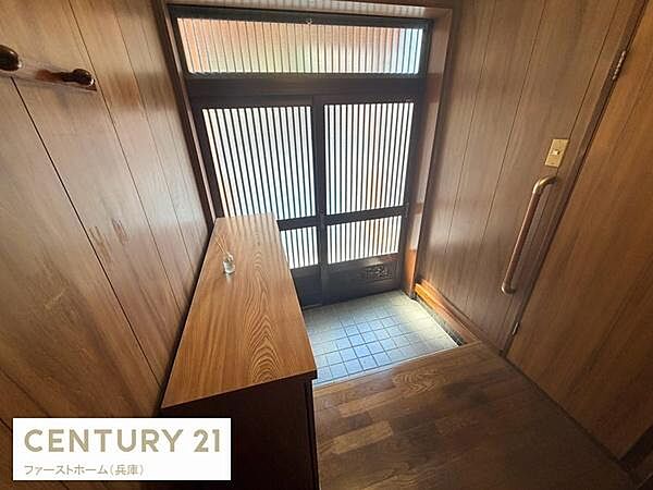 玄関は木目調の壁と収納が調和し温かみのある印象です。採光性のあるドアが明るさを取り入れています。手すりも設置されていて使いやすく配慮されています。落ち着いた雰囲気の空間です。