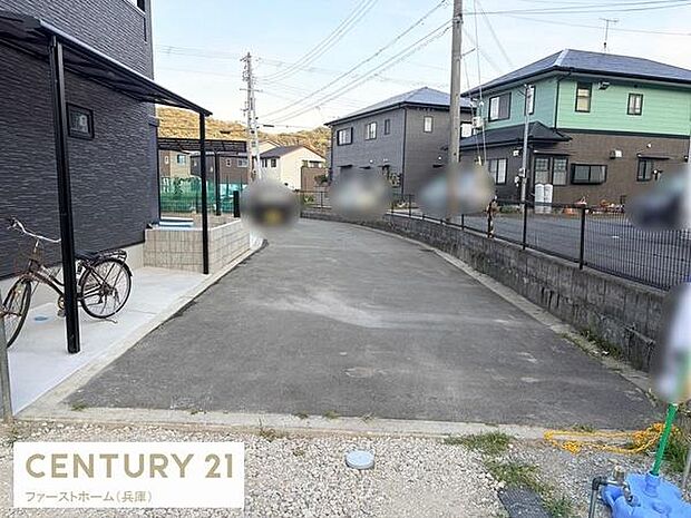 住宅街の落ち着いた雰囲気が漂う前面道路の写真です。車の通行もスムーズにできる幅を確保しています。周辺には新しい住宅が並び整然とした街並みが特徴的です。敷地へのアクセスもしやすい舗装された道路です。