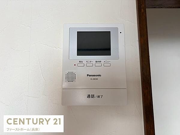 壁に設置されたパナソニック製のインターホンです。モニターやボタンがわかりやすく配置されており操作もシンプルです。通話機能や呼出し機能が備わっています。住まいの安心をサポートする設備です。