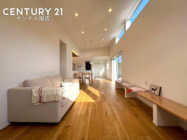 勾配天井を採用した開放的なリビング。天井が高く広がりを感じる空間設計で、窓からの光もたっぷり。家族が自然に集まる心地よいくつろぎの場所です。