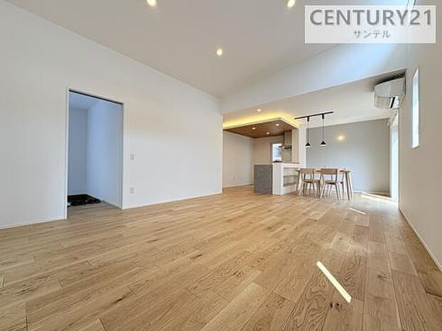 勾配天井を採用した開放的なリビング。天井が高く広がりを感じる空間設計で、窓からの光もたっぷり。家族が自然に集まる心地よいくつろぎの場所です。