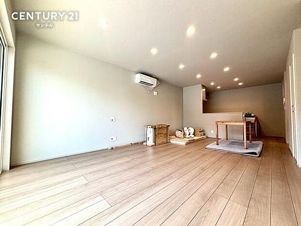 淡いグレーのアクセントクロスと、温かみのあるフローリングが美しく調和したナチュラルモダンな空間。天井のダウンライトがスッキリとした広さを演出し、お気に入りの家具もスタイリッシュに引き立ちます。