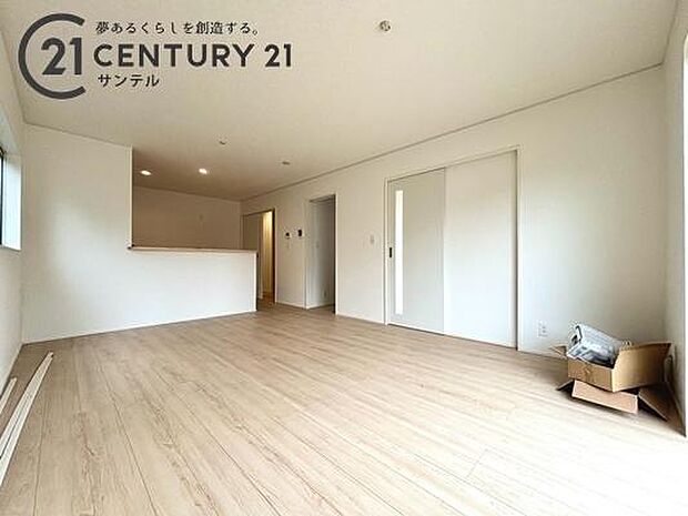 木のぬくもり溢れるフローリングと白壁が調和した、広々とした快適なリビング。家具を配置してもゆとりがあり、対面キッチンから空間全体を見渡せるため、家族の繋がりを常に感じながら心地よくリラックスできます。