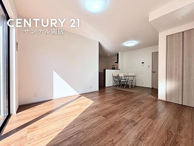 木目のフローリングが空間全体に温かみを与えるリビング。対面キッチンとつながり、家族の様子を感じながら過ごせる間取りです。