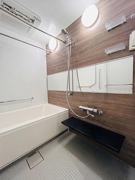 長いワイドミラーが設置されている為空間に奥行きが生まれ、バスルーム全体が実際の広さ以上にゆったりと感じられます。白と木目調の壁面がとても明るく開放的な印象です。