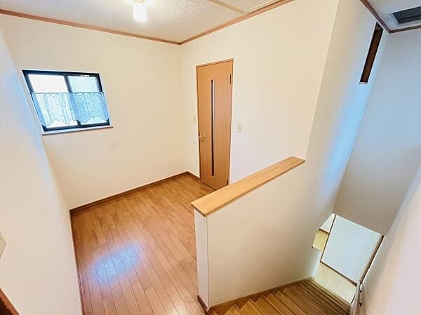 木目調の綺麗なフローリングと明るい壁紙が魅力の2階ホールです。窓から自然光が差し込み、風通しも良好。※AIによる画像加工を行っております。