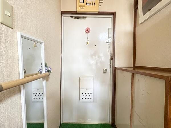 身だしなみチェックに便利な全身鏡や手すりを完備！シューズボックスも備わり、靴類をすっきり収納できます。白を基調とした、明るく清潔感のある玄関です。※AIによる画像加工を行っております。