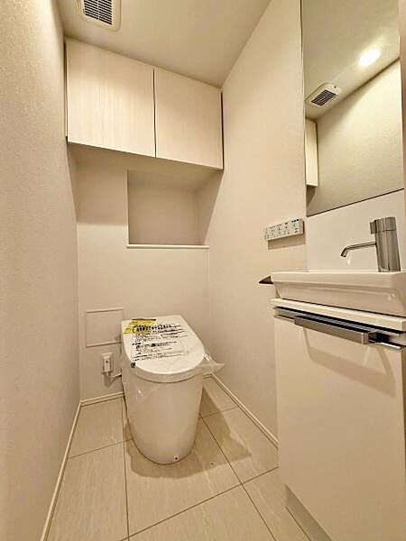 【トイレ】上部に棚を設けた温水洗浄便座付のトイレ。トイレットペーパーや掃除用品なども置いておくことが出来ます。
