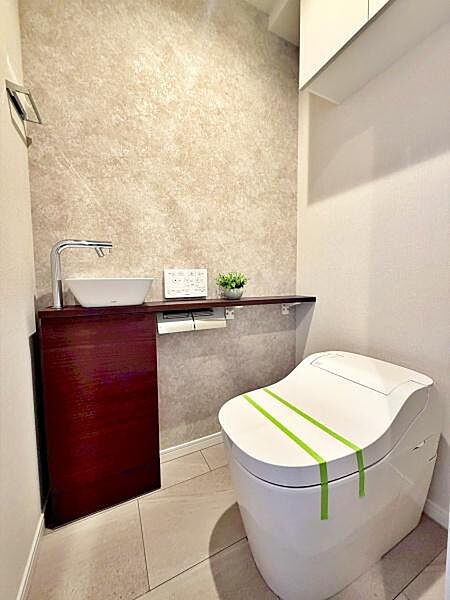 【トイレ】上部棚と手洗いカウンターを備えたトイレ。トイレットペーパーや掃除用品などの収納にも便利です。