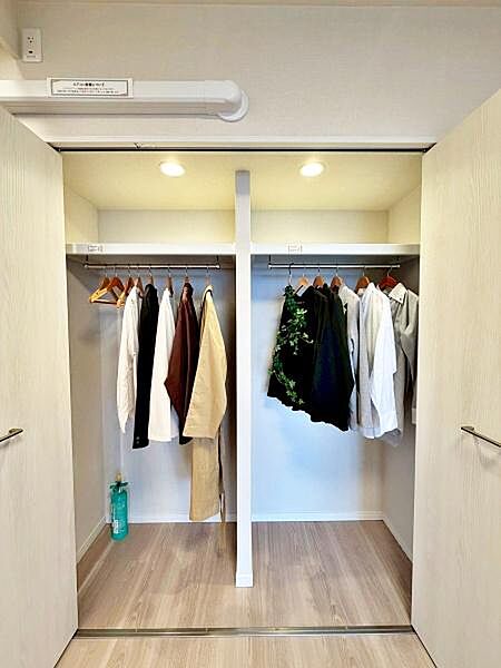 【収納】ハンガーパイプと上部棚を備えたクローゼット。物を取り出しやすいクローゼット内照明付き。