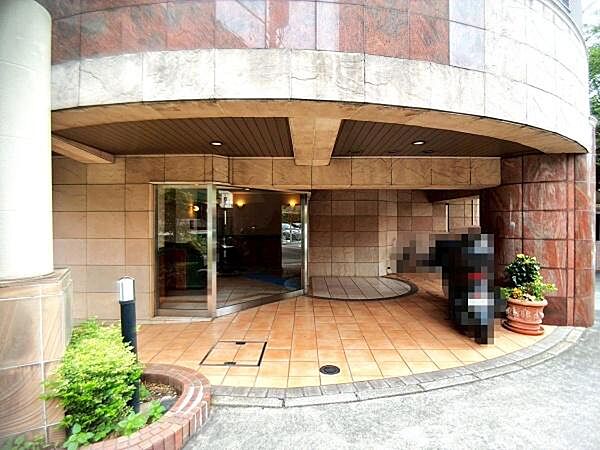 【エントランス】ガラス張りの自動ドアを採用したエントランス。植栽も丁寧に手入れされています。