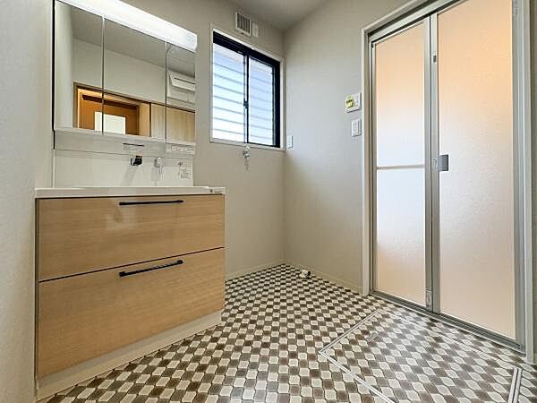 リフォームで洗面台を新しく交換。大きな鏡付きの洗面台が設置されており収納も充実しています。窓から光が入り明るい空間です。