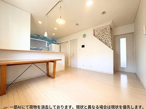 明るい内装と広々としたスペースが魅力的なリビングです。天井の照明が室内をやさしく照らします。階段横のデザインにも個性が感じられます。