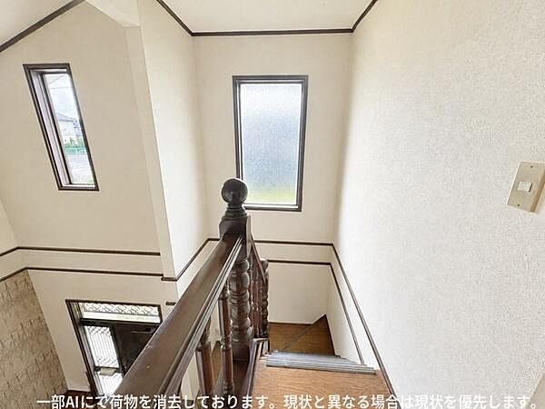階段の吹き抜け部分に大きな窓が配置されており自然光がしっかりと差し込みます。白を基調とした壁面と濃色の手すりが調和しています。天井が高く開放感があります。
