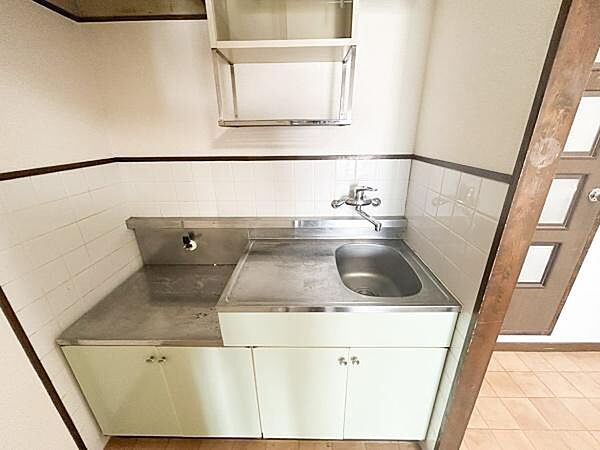 シンプルなキッチンです。収納棚が付いているため小物の整理にも便利です。ステンレスの作業スペースはお手入れがしやすいです。コンパクトな設計で空間を有効に使えます。