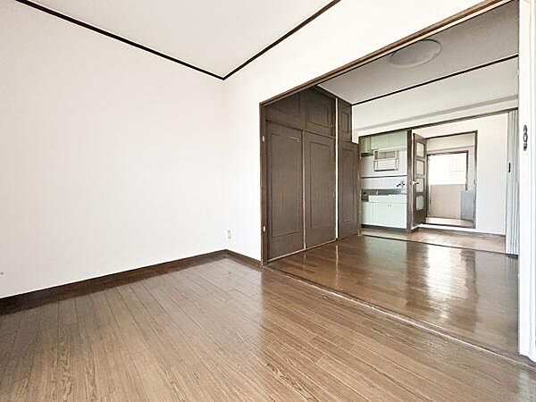 シンプルな内装で幅広いインテリアに対応しています。洋室とキッチンが仕切られていて使い分けがしやすいです。大きな開口部があり空間にゆとりを感じられます。床や壁の色合いが落ち着いた印象を与えています。