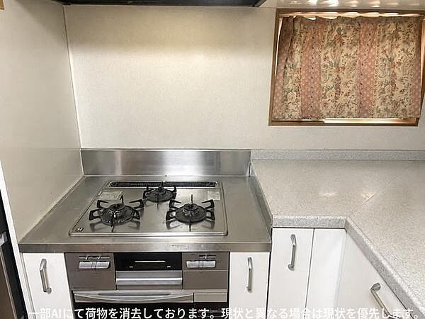 シンプルなデザインのキッチンで作業スペースがしっかりと確保されています。三口コンロが備わっており調理がしやすい仕様です。窓からの採光によりキッチン全体が明るい雰囲気です。