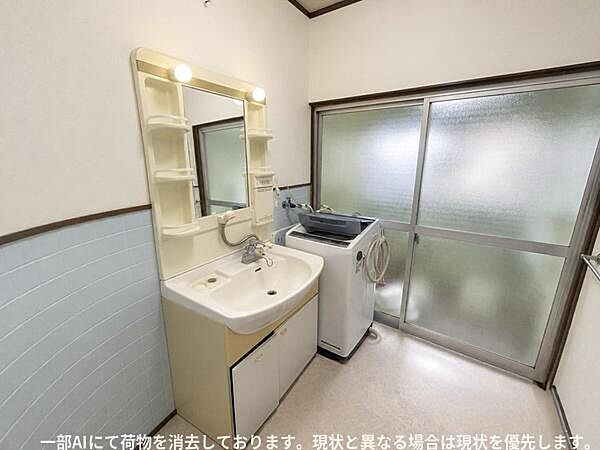 洗面台には収納棚が備わっており小物の整理に便利です。広めのスペースがあり洗濯機も設置できます。鏡の両側には照明も付いています。
