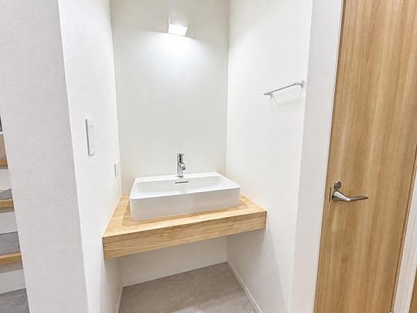 1階の手洗い用洗面台。木のカウンターに白いボウルを合わせました！帰宅時やお客様の来訪時に、2階へ上がらずに手を洗えます。※AI加工により家具を消去したイメージです。