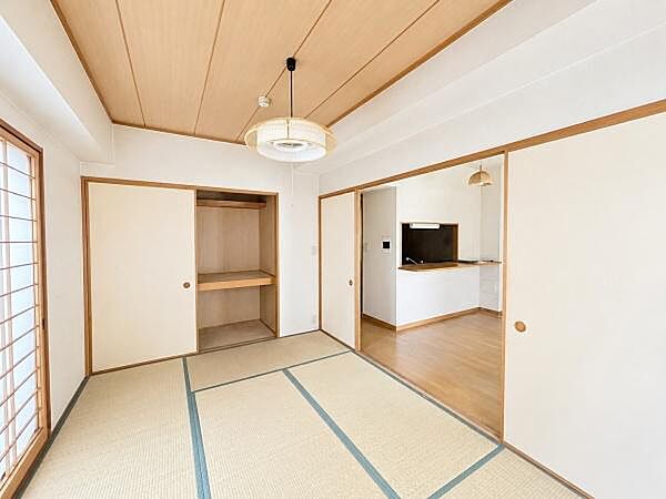 :LDKに隣り合う6帖の和室です。襖を開ければLDKとつなげて使え、閉じれば個室として使えます。※現況写真から家具等を消去したAI加工イメージです