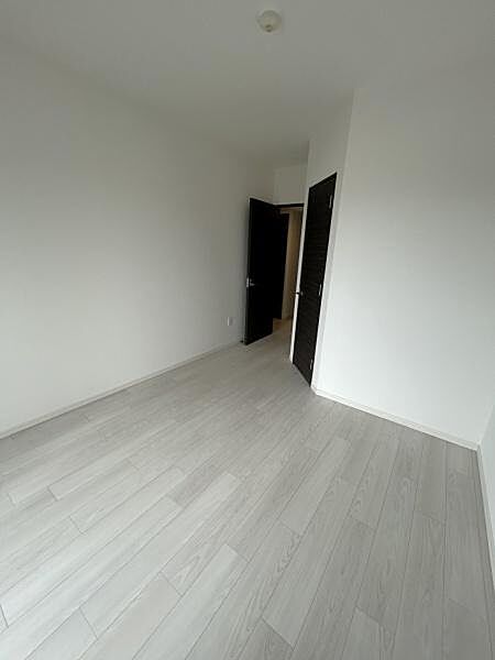 明るい木目調のフローリングとダークブラウンの建具が調和した、落ち着きのある室内です。約7帖の洋室です。ゆとりある広さで、主寝室としてもご利用いただけます。