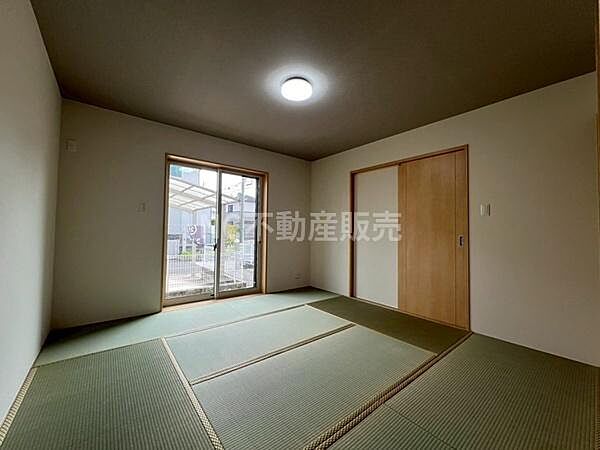 落ち着きのある和室です。畳の質感が空間を引き締めています。大きな窓からは自然光が入り開放感があります。引き戸で使い勝手にも配慮されています。シンプルな内装が特徴です。