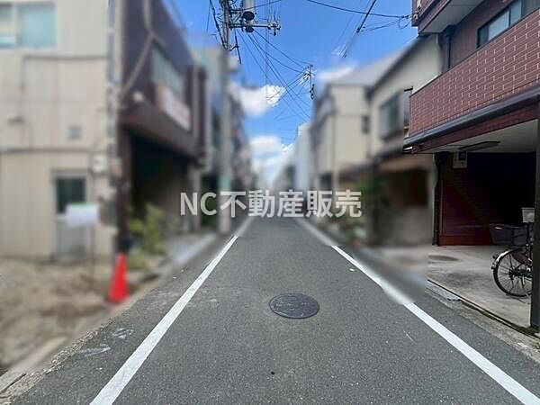 前面道路は舗装されており住宅街ならではの落ち着いた雰囲気が感じられます。建物が道に沿って並んでいるため整然とした印象です。周囲には電線も整備されています。