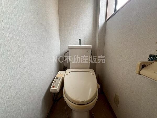 明るい窓付きのトイレで採光が確保されています。温水洗浄便座が設置されており使い勝手が良い仕様です。壁や床もシンプルなデザインでお手入れがしやすい印象です。清潔感のある空間となっています。