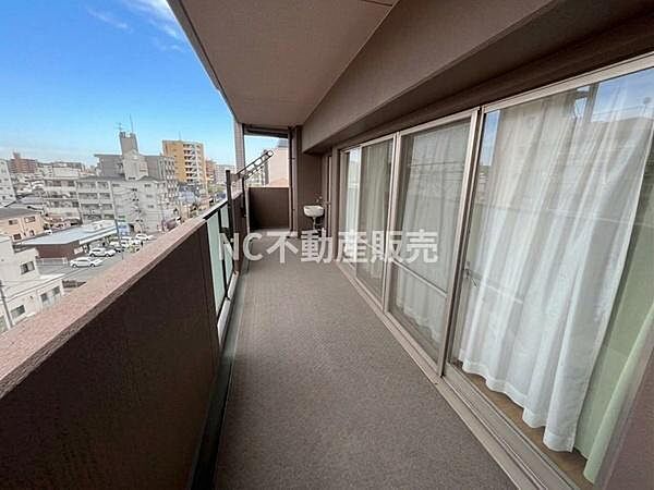 開放感のある広々としたバルコニーです。高層階からの眺望が魅力です。ガラス手すりが外観の印象を引き立てます。窓からの採光も良好です。