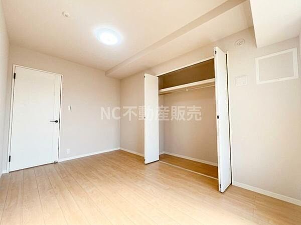 明るい色調のフローリングが特徴の洋室です。広々とした空間で使い勝手の良い収納が備わっています。シンプルな内装でさまざまなインテリアに対応できます。ドアやクローゼットのデザインも統一感があります。