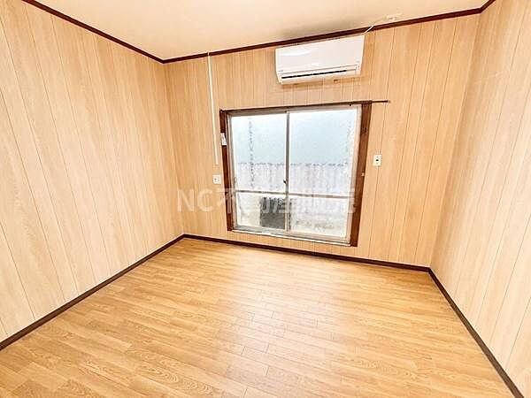 木目調のフローリングと壁が温かみを感じさせる洋室です。大きな窓が室内に明るさをもたらします。エアコン付きで快適に過ごせます。シンプルな空間なので用途に合わせてレイアウトが可能です。