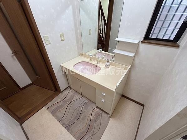 洗面台はシンプルなデザインでお手入れがしやすい造りです。収納スペースも備えており小物の整理に便利です。大きな鏡が設置されており身だしなみのチェックも快適に行えます。