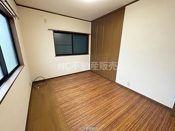 木目調の床が落ち着いた雰囲気を感じさせる洋室です。大きめのクローゼットが備わっています。二面採光で室内が明るくなっています。シンプルな造りで家具の配置がしやすい空間です。