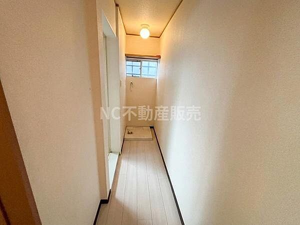 明るい照明と窓からの自然光で廊下全体が落ち着いた印象です。床と壁のシンプルな色合いが清潔感を演出しています。コンパクトながらも使いやすい空間設計が特徴です。無駄のない直線的なレイアウトが魅力です。