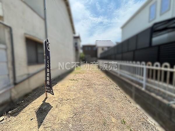 両隣が建物で囲まれた現地土地写真です。日当たりの様子や周辺の建物の距離感が確認できます。無駄のない整形地で現地の状況を把握しやすい写真になっています。敷地の前後も見通しが良好です。