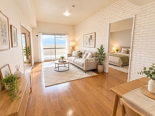 木目調フローリングが印象的なリビングです。白いレンガ調クロスがアクセントとなり明るく開放感のある空間です。大きな窓から自然光が差し込んでいます。隣室への動線もスムーズです。